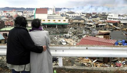 Two-women-look-at-buildings-that-were-devastated-by-massive-quake-and-tsunami-at-Japan